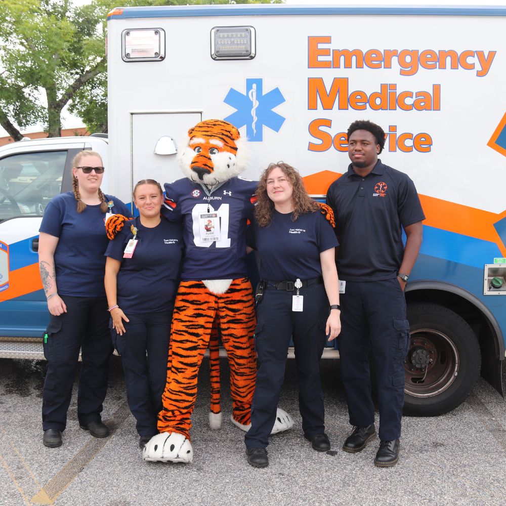 East Alabama EMS employees pose for a photo with Aubie the Tiger.